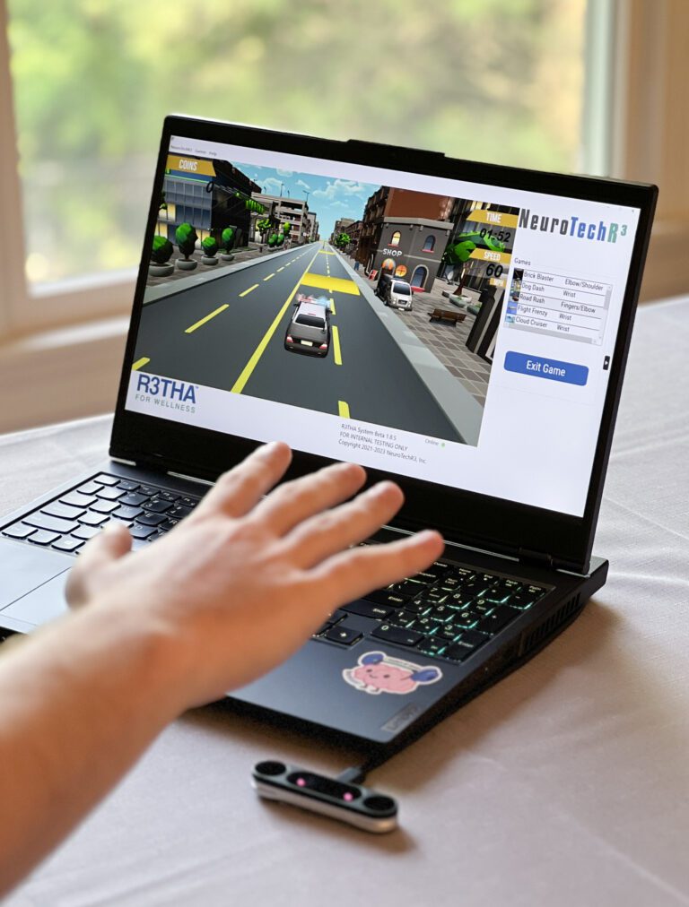Person using their hand above a camera sensor to play a driving game on a laptop